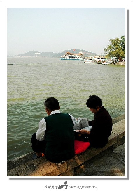喧囂的旅遊人潮中也有安靜的一隅，老夫妻在太湖邊獨自享受著心中的寧靜。